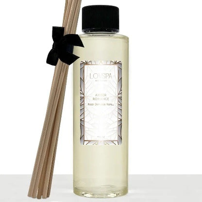 LOVSPA Amber Romance reed diffuser refill bottle with natural reeds, styled with amber tones and soft floral accents on a warm, elegant background.